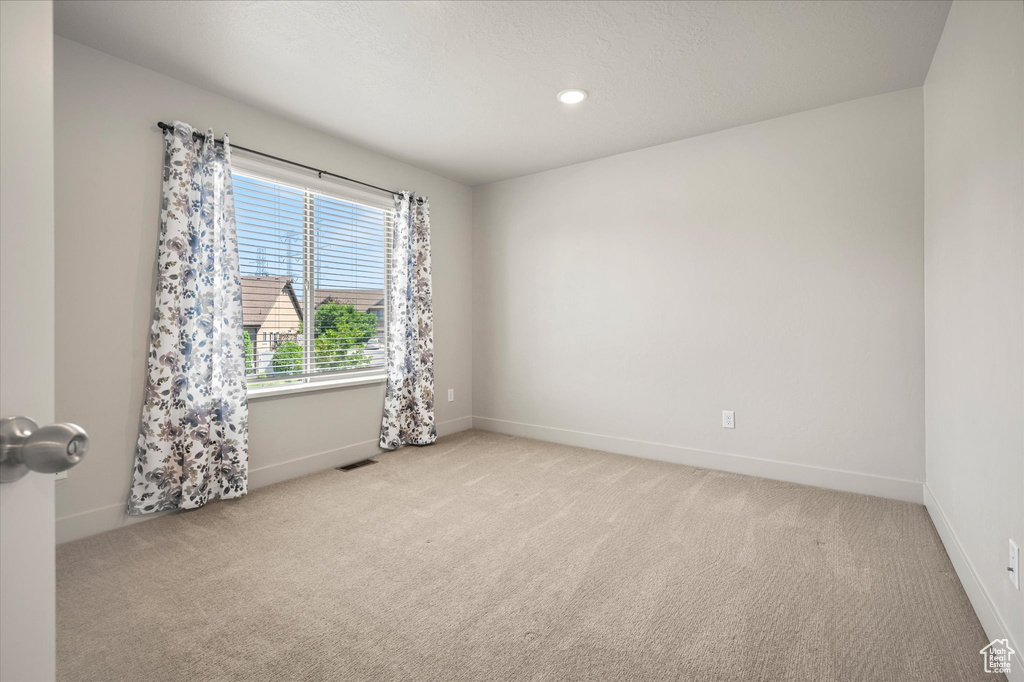 Empty room with baseboards, light carpet, and recessed lighting