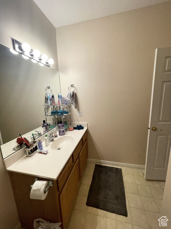 Bathroom featuring vanity, baseboards, and tile patterned flooring