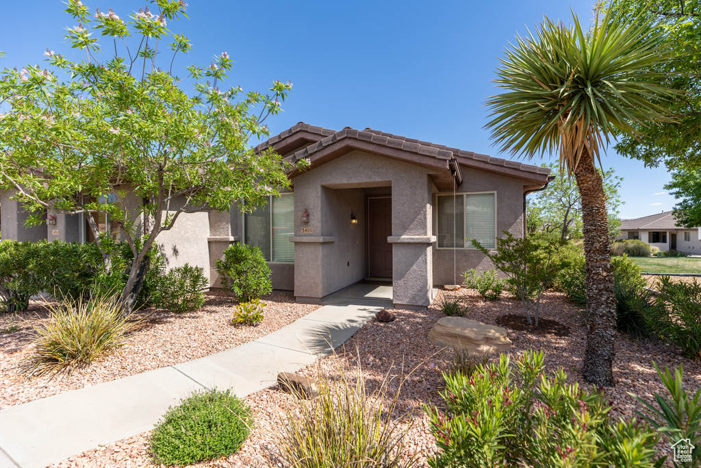 Ranch-style house featuring stucco siding and a tiled roof