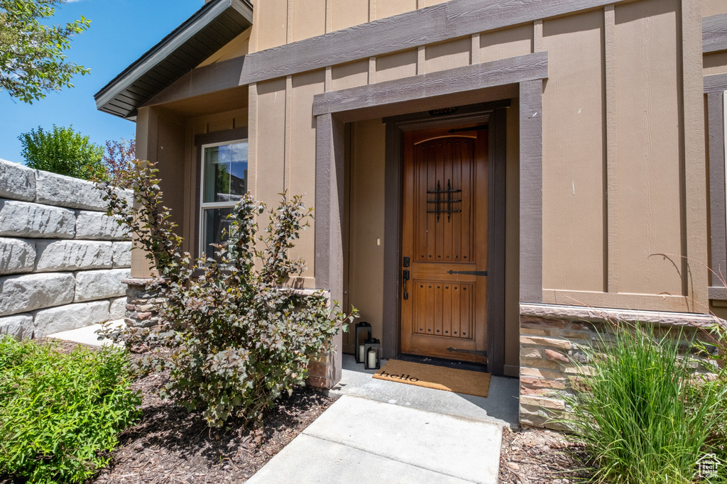 View of exterior entry featuring stone siding and board and batten siding