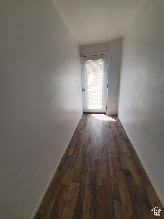 Corridor featuring dark wood-style flooring and baseboards