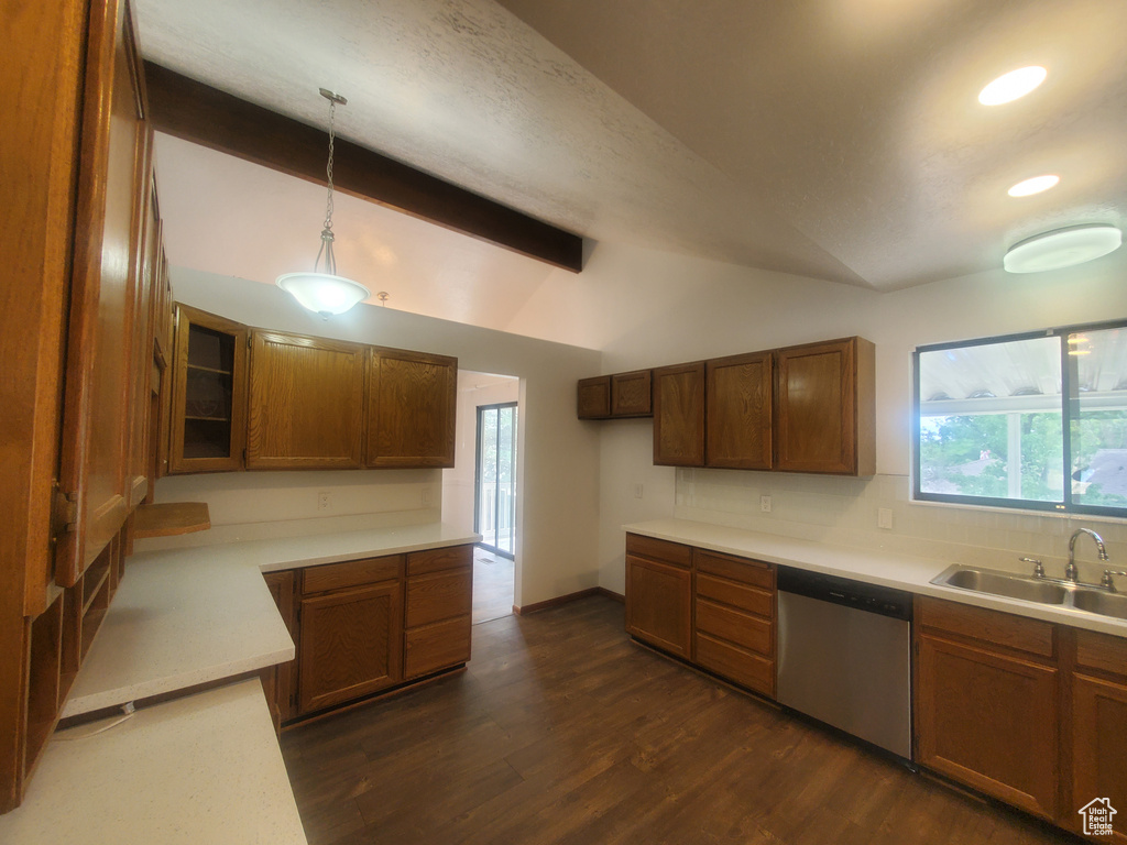 Kitchen with stainless steel dishwasher, a sink, dark wood-style floors, light countertops, and pendant lighting