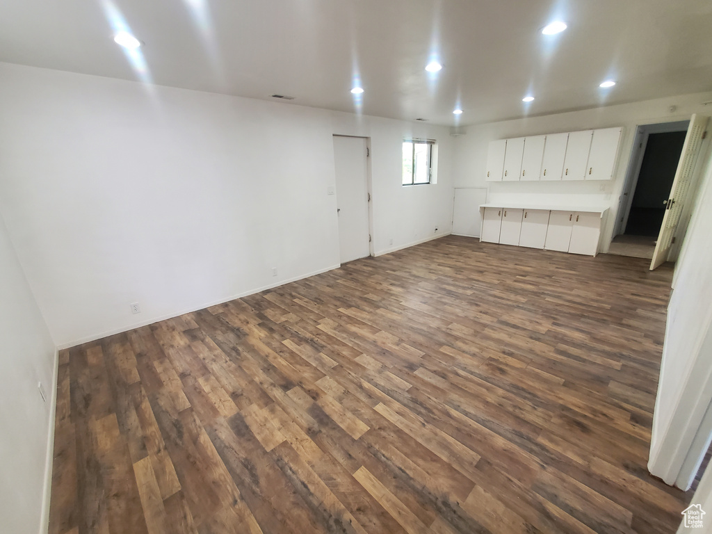 Below grade area with dark wood-style floors and recessed lighting