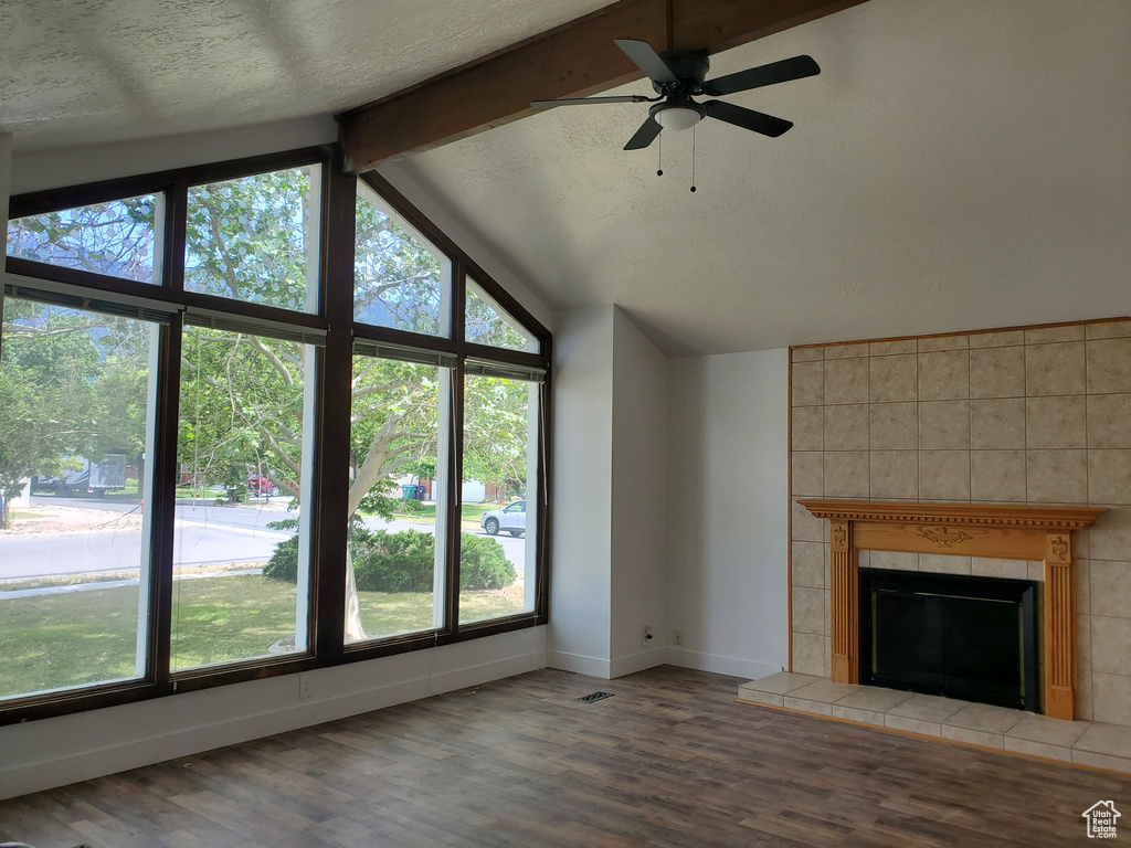 Unfurnished living room featuring plenty of natural light, baseboards, and wood finished floors