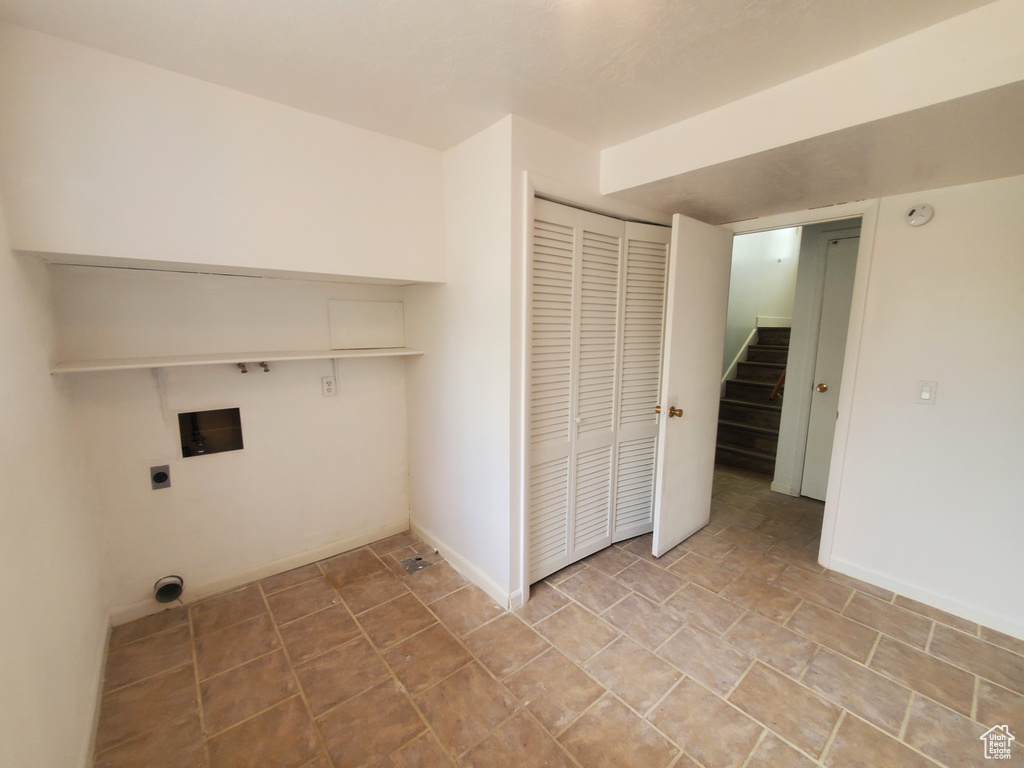 Laundry room featuring hookup for an electric dryer, hookup for a washing machine, baseboards, and stone finish flooring