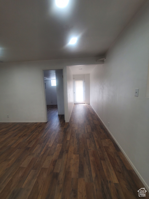 Unfurnished room with dark wood-type flooring and baseboards