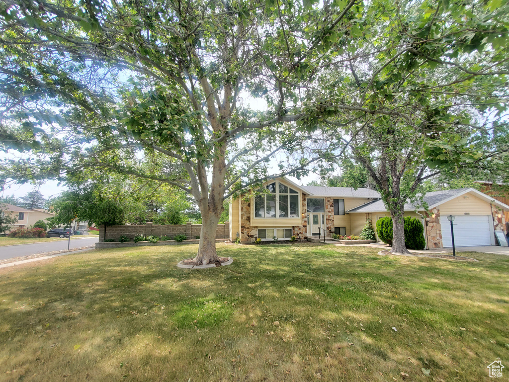 Tri-level home with a front lawn and an attached garage