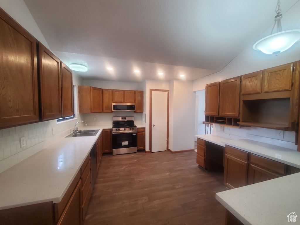 Kitchen featuring appliances with stainless steel finishes, a sink, recessed lighting, dark wood-style flooring, and decorative backsplash