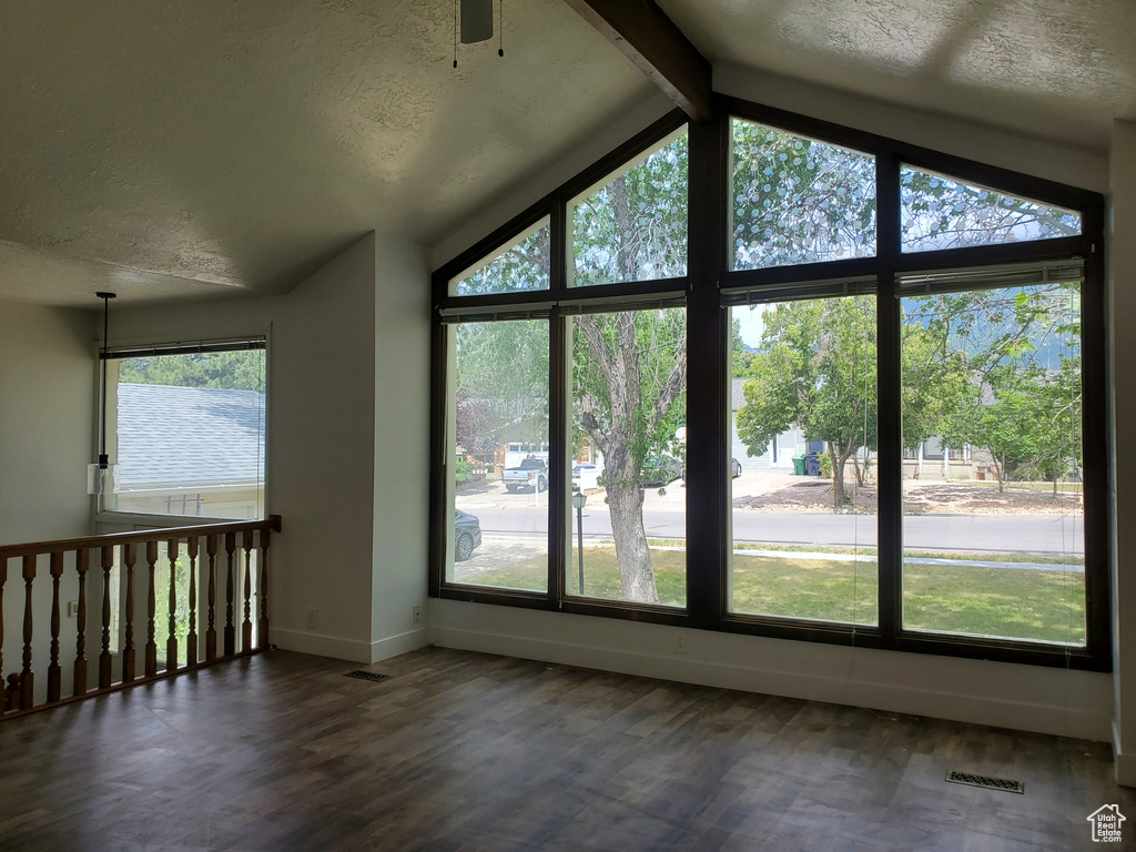 Unfurnished room featuring baseboards, dark wood-style floors, a textured ceiling, and ceiling fan