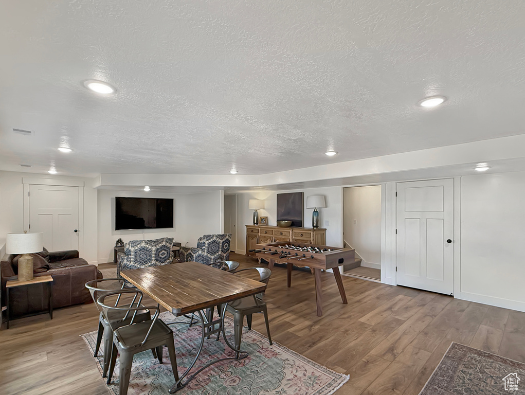 Dining space with a textured ceiling, light wood finished floors, and recessed lighting