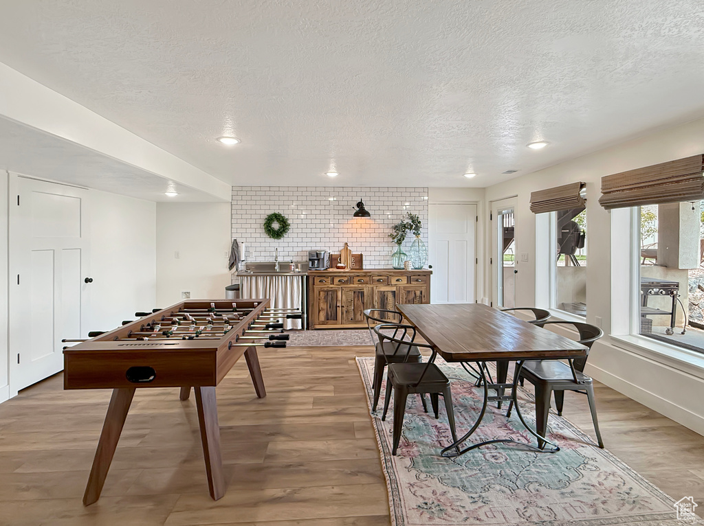 Game room featuring a textured ceiling, light wood finished floors, recessed lighting, and a sink