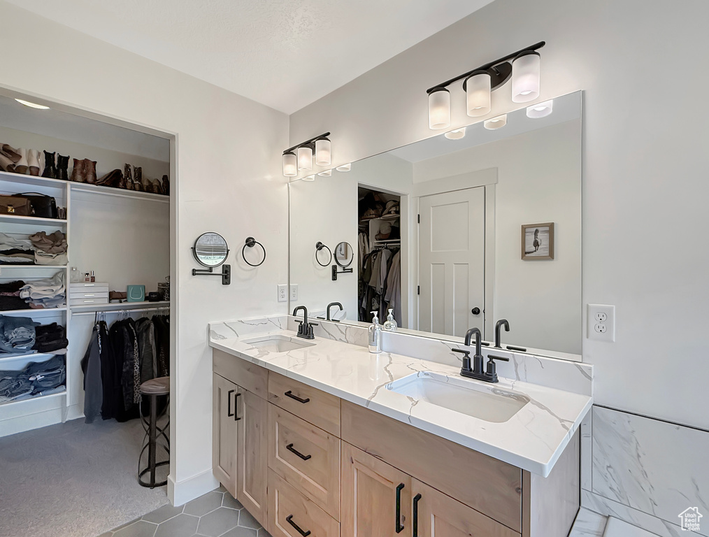 Bathroom with double vanity and a spacious closet