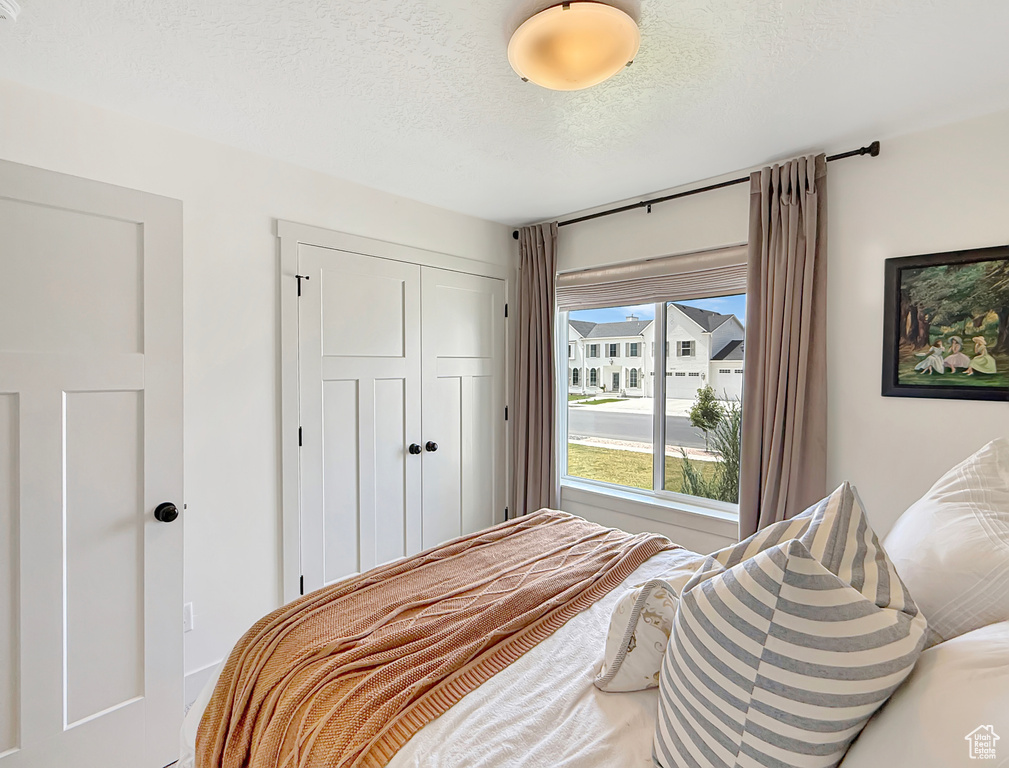 Bedroom with a closet and a textured ceiling