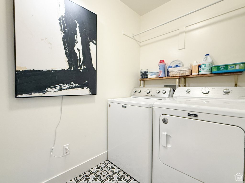 Washroom with washing machine and clothes dryer and baseboards