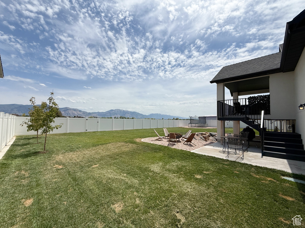 View of yard featuring stairway, a mountain view, a patio area, and an outdoor fire pit