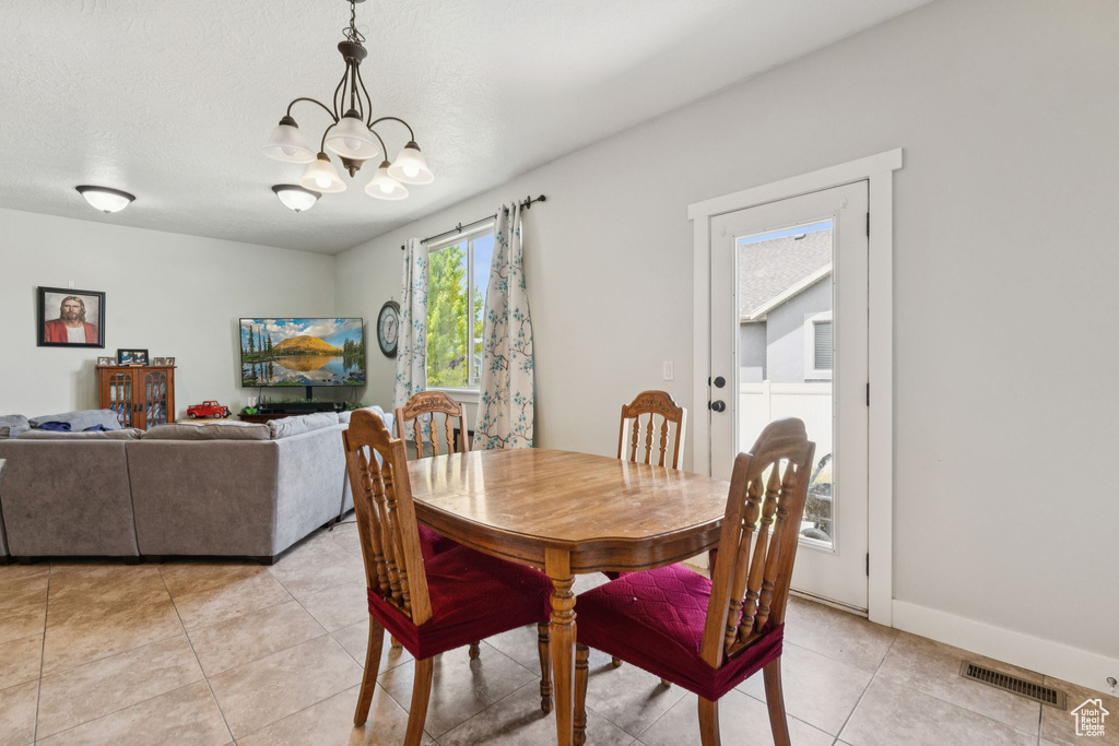 Dining area with a chandelier and light tile patterned floors