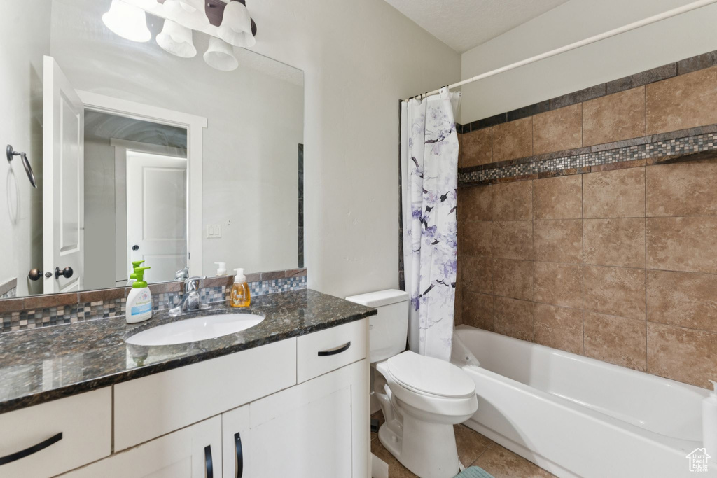 Full bath with vanity, toilet, tile patterned flooring, and shower / tub combo