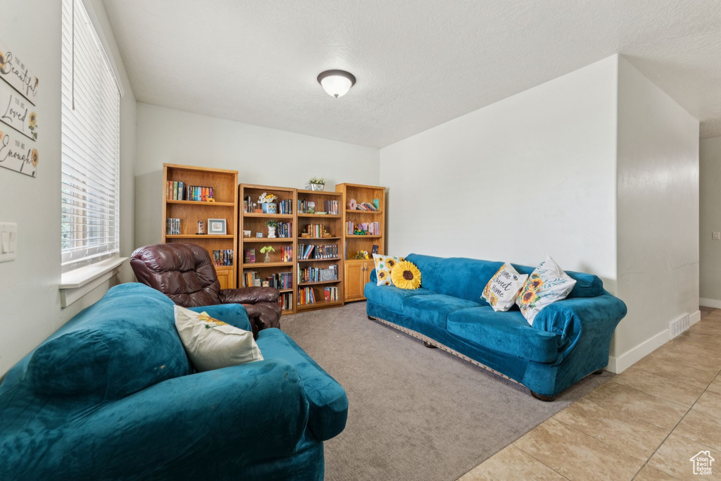 Tiled living area featuring a textured ceiling