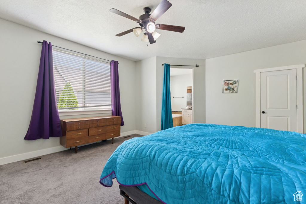 Bedroom featuring carpet floors, baseboards, a textured ceiling, ceiling fan, and connected bathroom