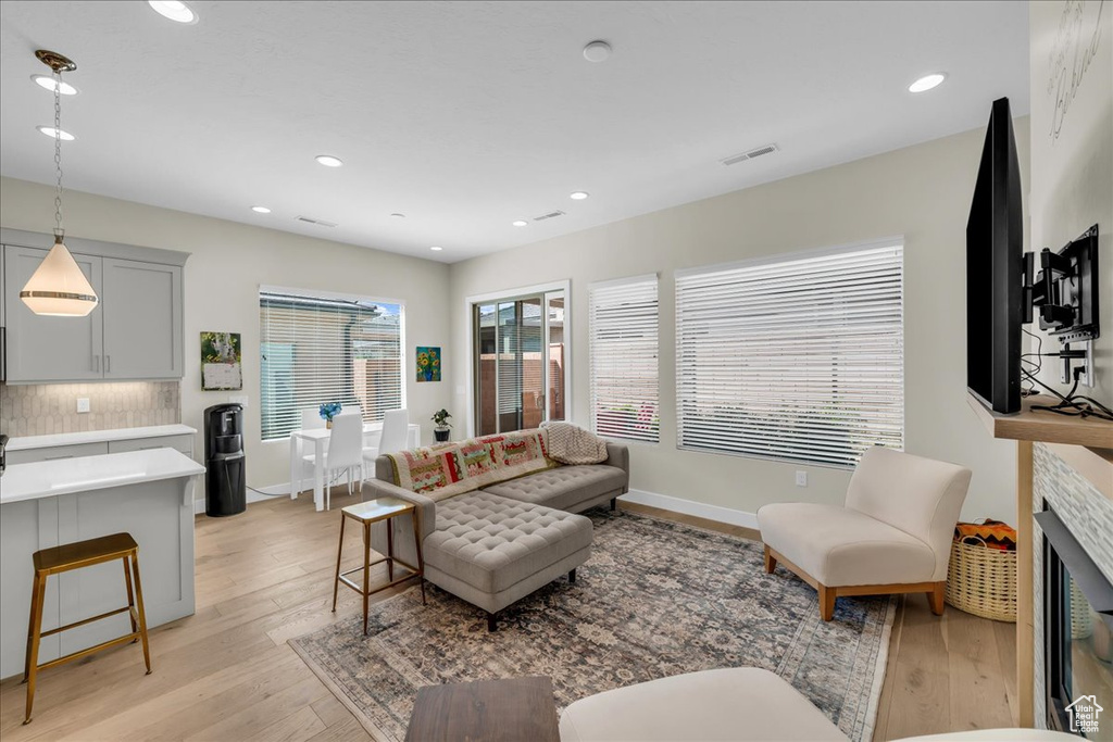 Living room with light wood-type flooring, recessed lighting, and baseboards