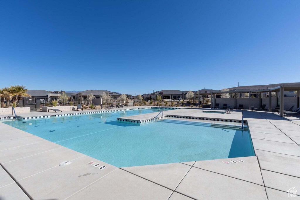 Community pool featuring a residential view, a hot tub, and a patio