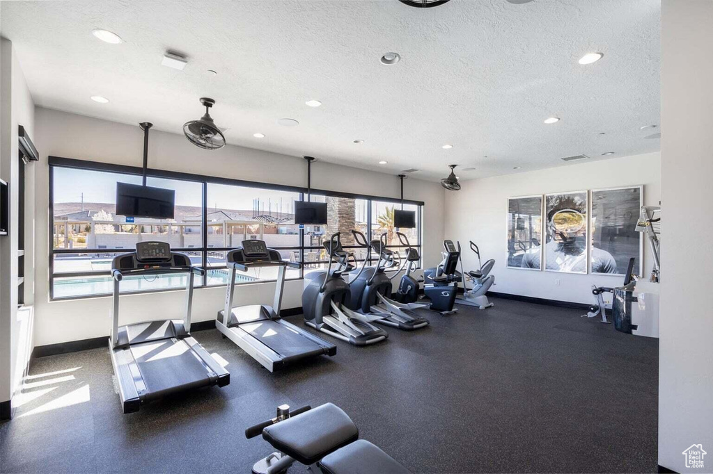 Workout area with recessed lighting, a textured ceiling, and baseboards