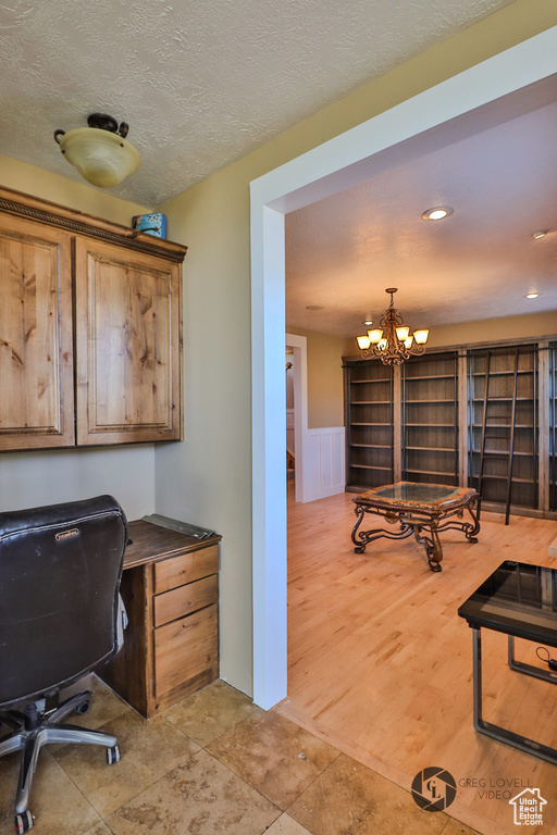 Office space with a chandelier, a textured ceiling, and recessed lighting