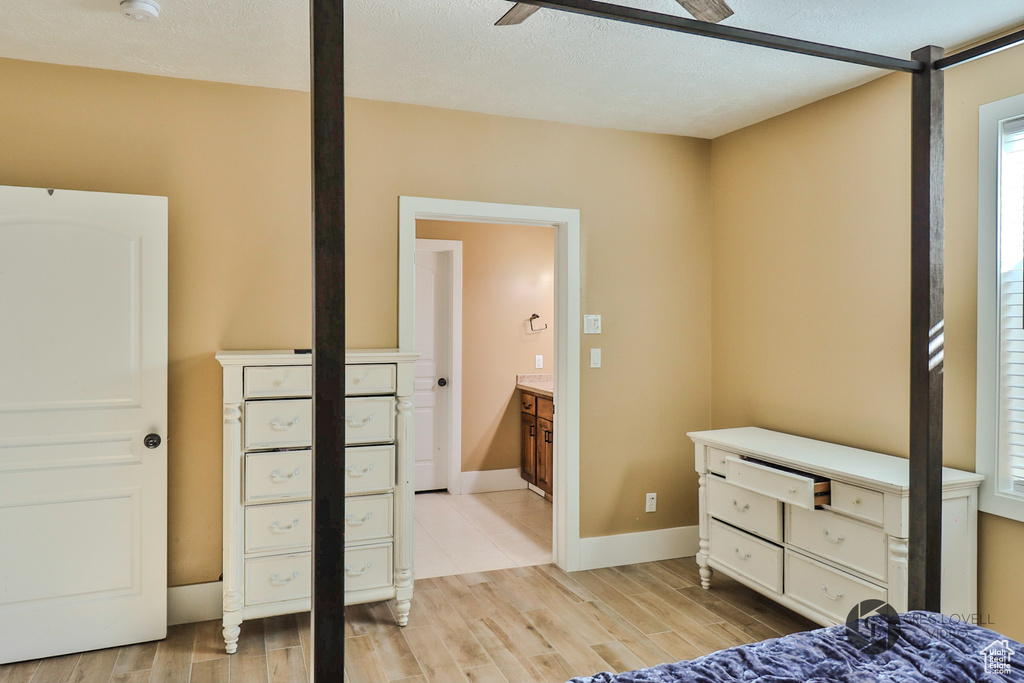 Bedroom featuring light wood finished floors, baseboards, and a ceiling fan