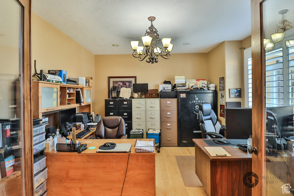 Office area with wood finished floors and a chandelier