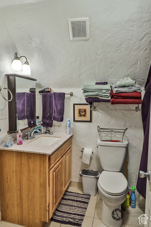 Bathroom with tile patterned floors, vanity, and toilet