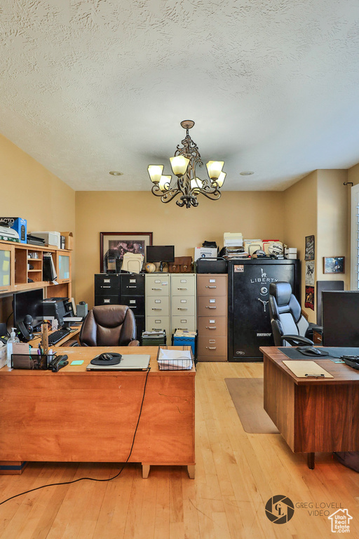 Office space with a chandelier, hardwood / wood-style flooring, and a textured ceiling