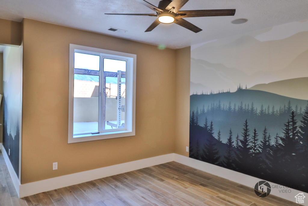 Spare room featuring a ceiling fan, baseboards, and wood finished floors