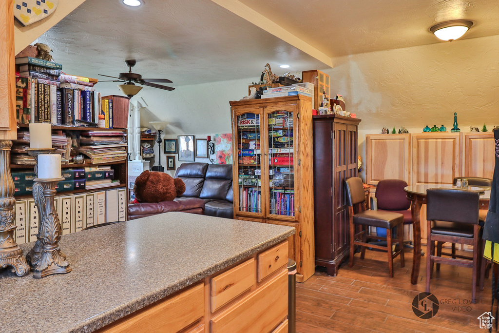 Kitchen with a ceiling fan, wood finished floors, a textured wall, recessed lighting, and open floor plan