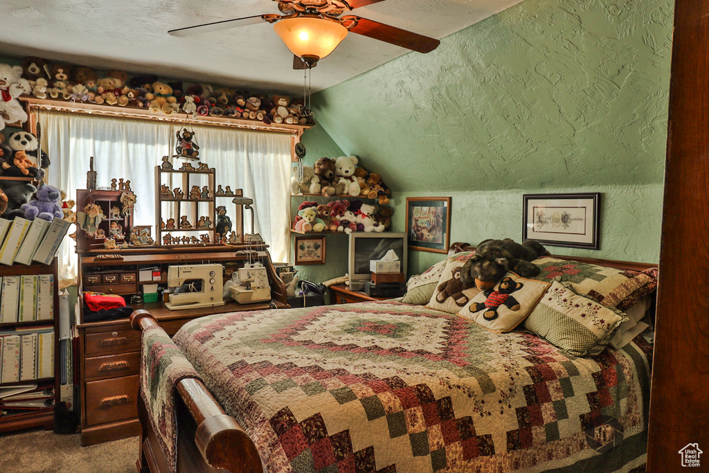 Carpeted bedroom with lofted ceiling, a textured wall, and a ceiling fan