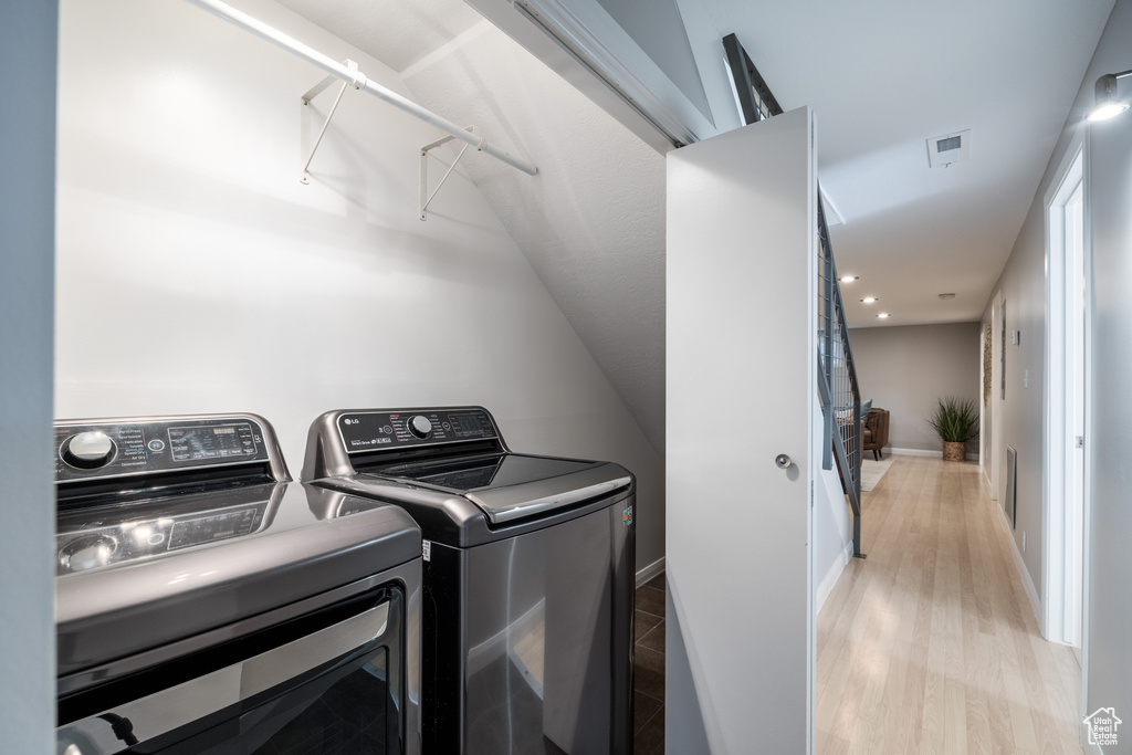 Washroom with washer and dryer, recessed lighting, light wood-style flooring, and baseboards