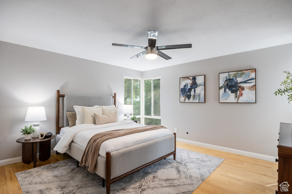 Bedroom featuring baseboards, light wood finished floors, and a ceiling fan