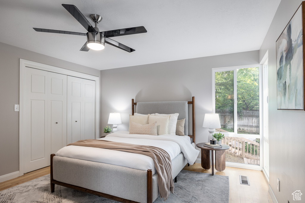 Bedroom featuring light wood finished floors, a closet, and ceiling fan