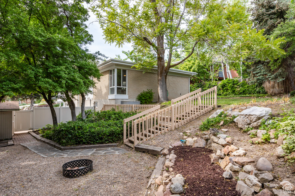 View of home\'s exterior featuring brick siding and a fire pit