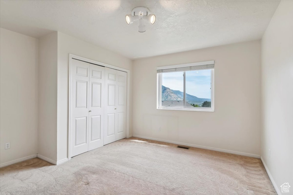 Unfurnished bedroom with carpet flooring, a closet, and baseboards