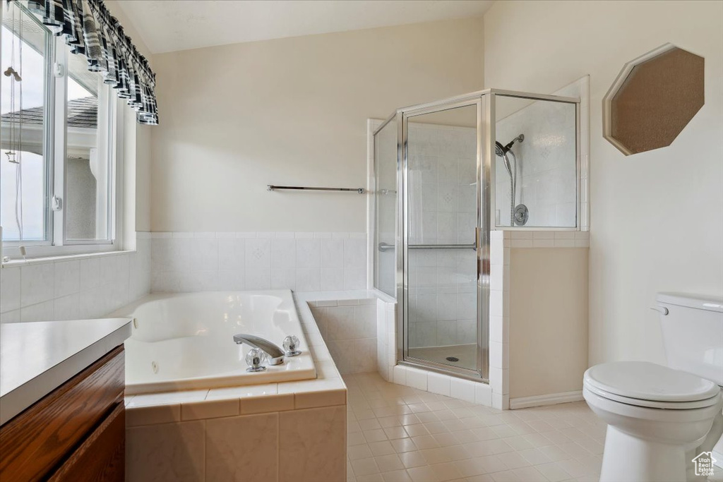 Full bathroom with a tub with jets, toilet, a stall shower, tile patterned floors, and vanity