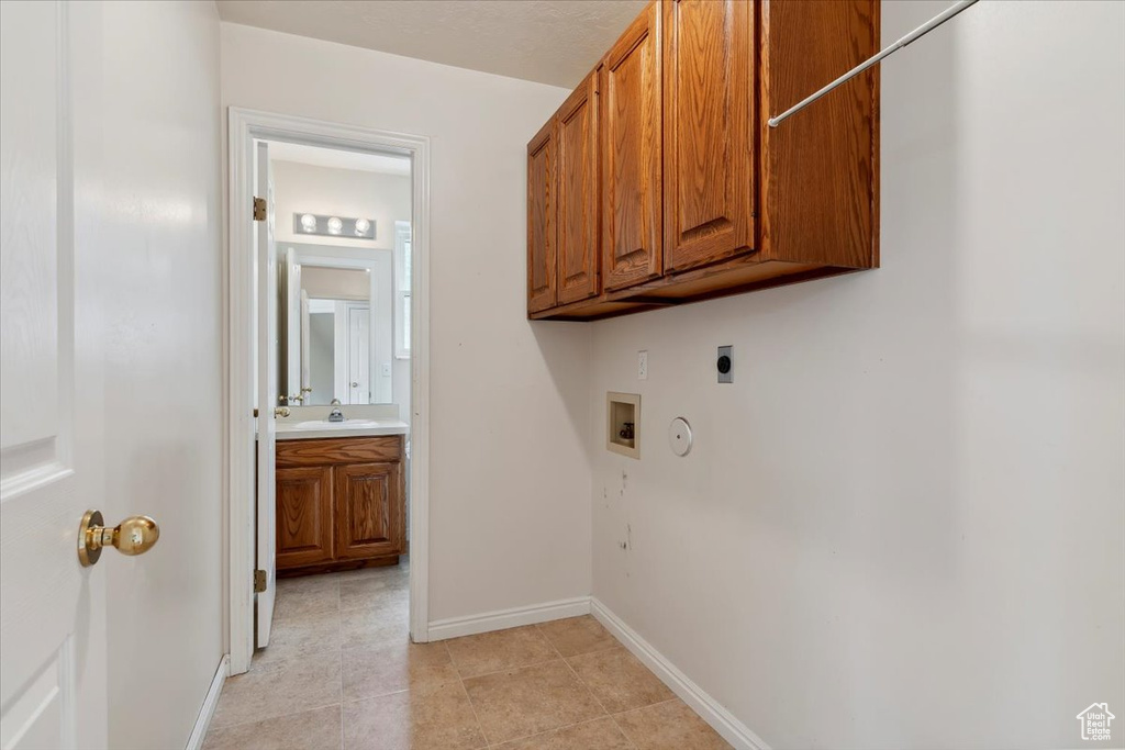 Laundry room featuring hookup for an electric dryer, cabinet space, hookup for a washing machine, gas dryer hookup, and baseboards