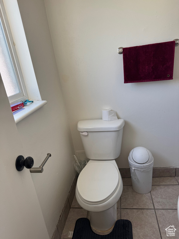 Half bath with toilet and tile patterned floors