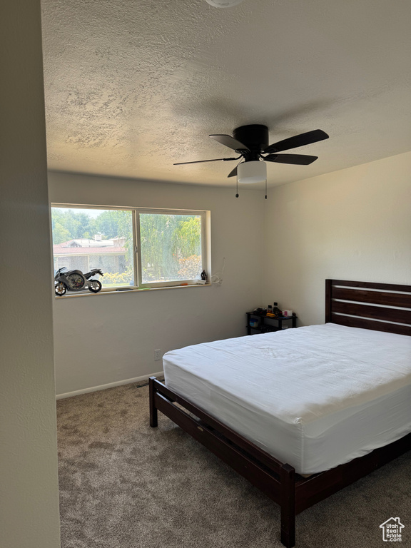 Bedroom featuring carpet flooring, a textured ceiling, a ceiling fan, and baseboards