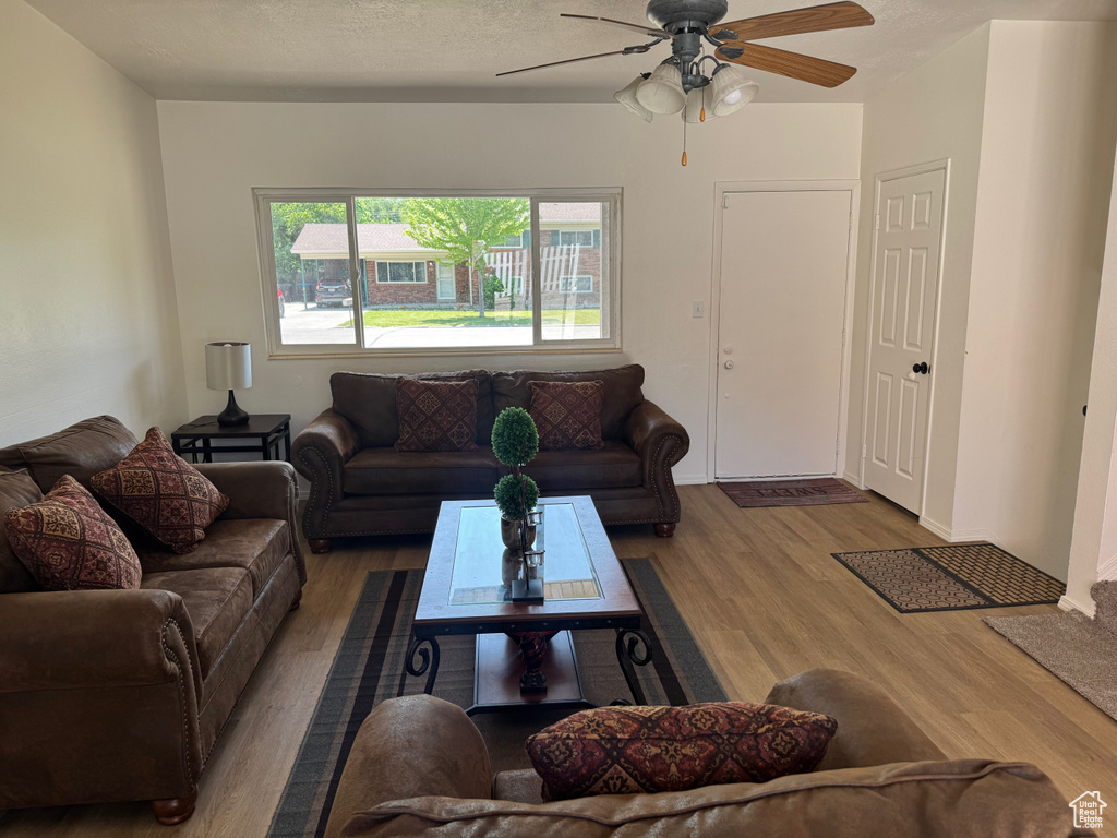 Living area with wood finished floors and ceiling fan
