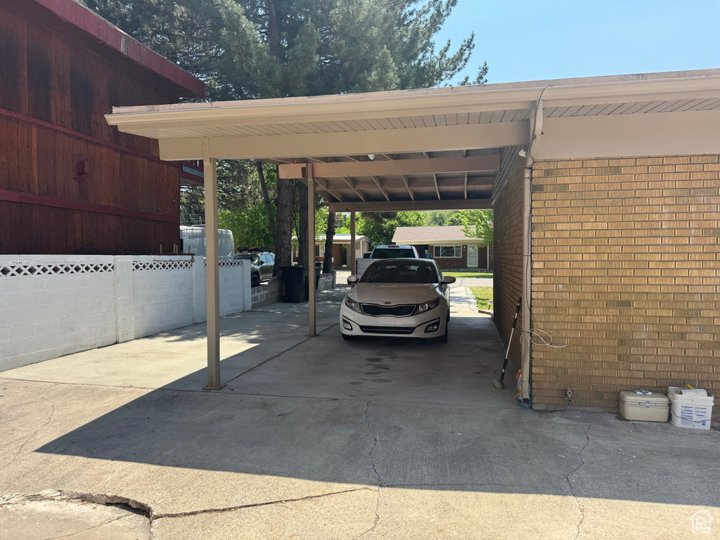 View of parking featuring driveway and a carport