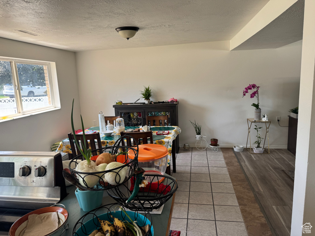 Tiled dining area featuring a textured ceiling