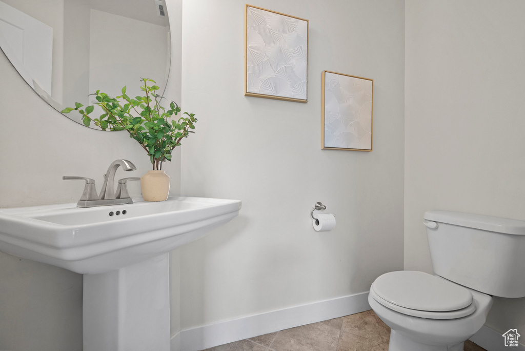 Bathroom with baseboards, toilet, and a sink