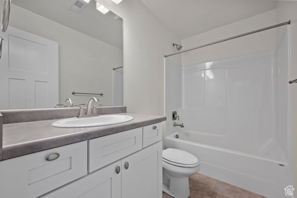 Bathroom with toilet, shower / bath combination, vanity, and tile patterned flooring