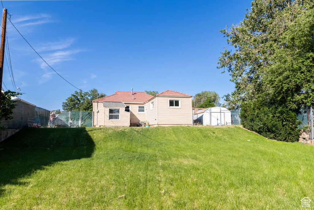 Back of property with a lawn