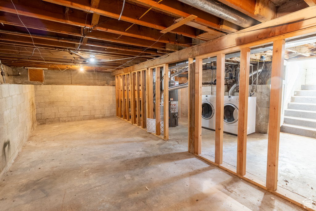 Unfinished basement featuring washer and clothes dryer and stairs